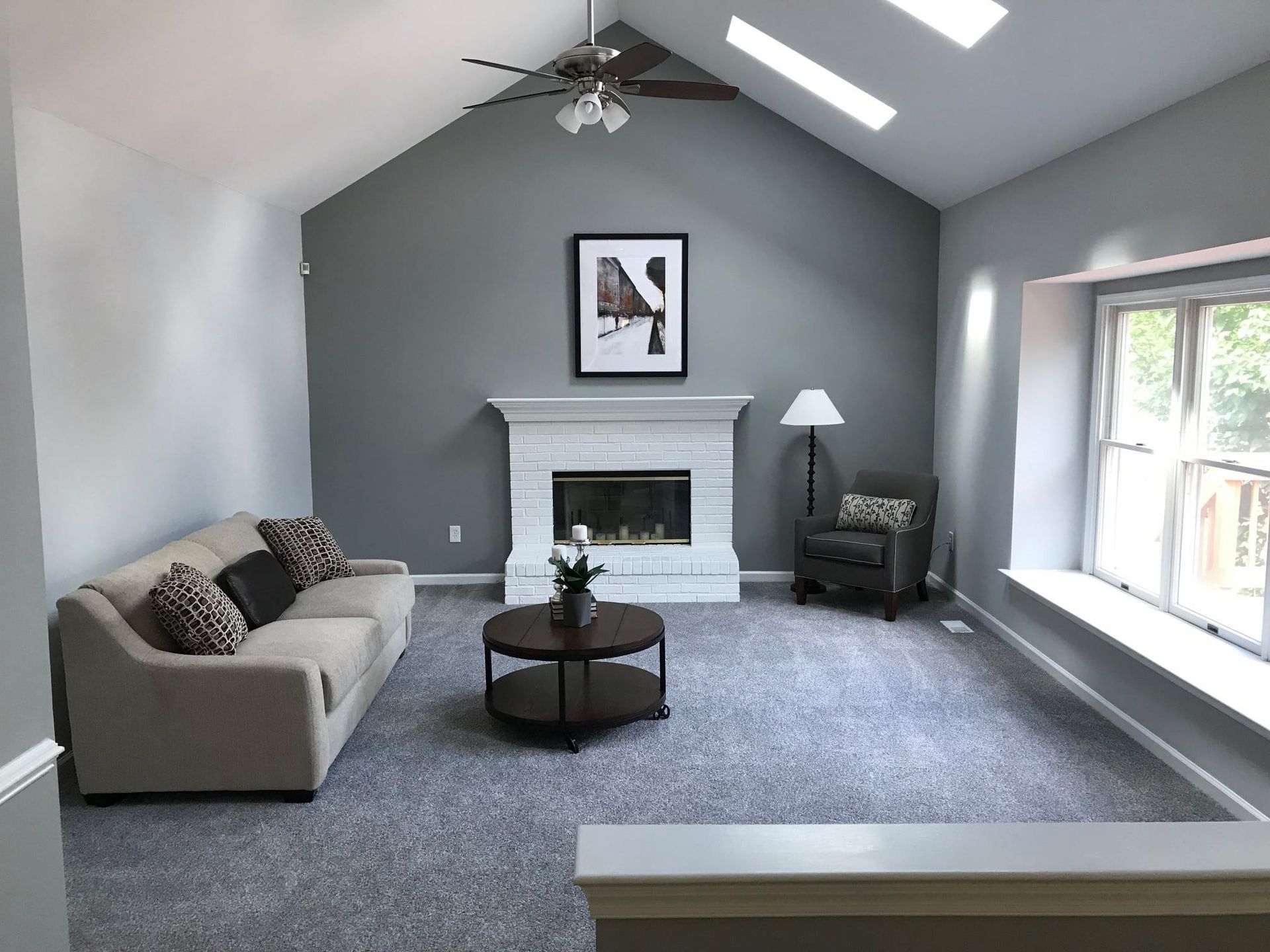 A living room with a fireplace and a ceiling fan