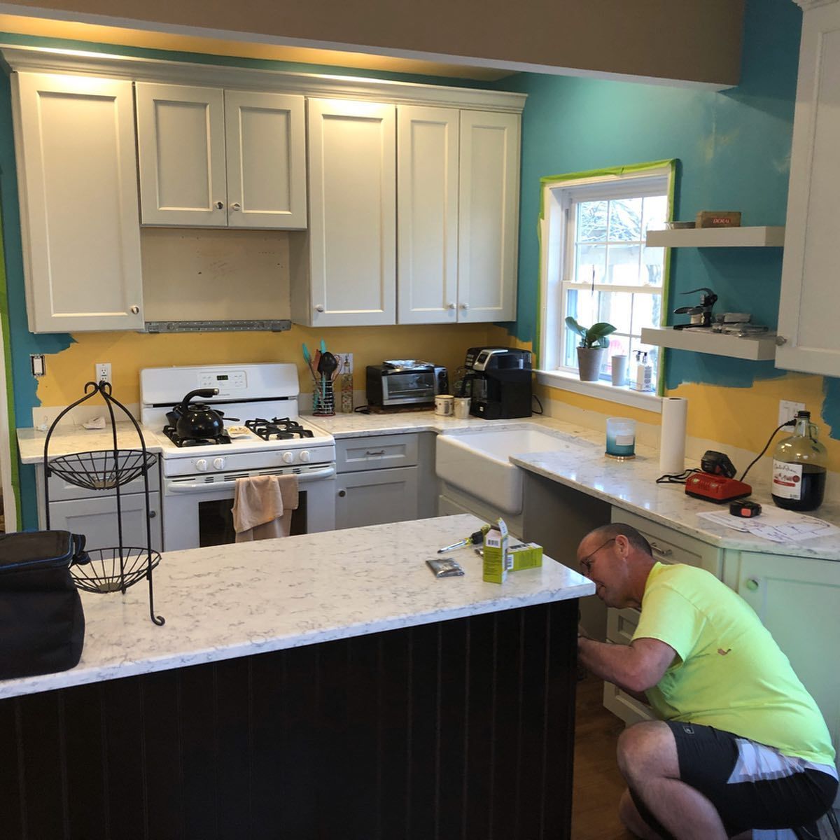 A man in a green shirt is working in a kitchen