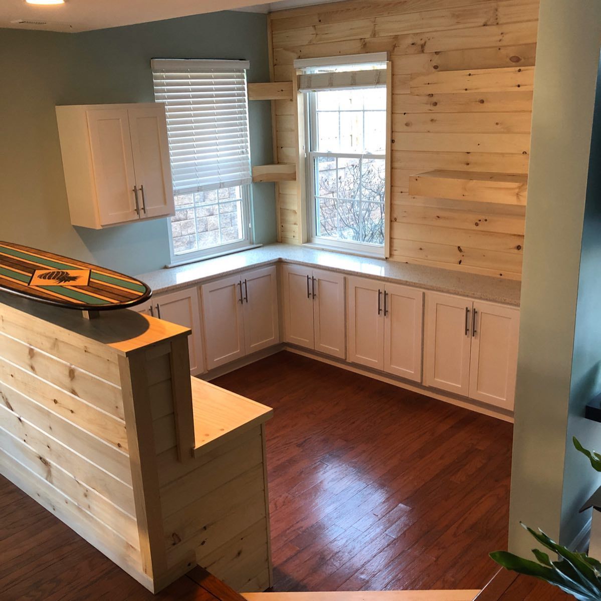 A skateboard is sitting on top of a wooden counter in a kitchen.