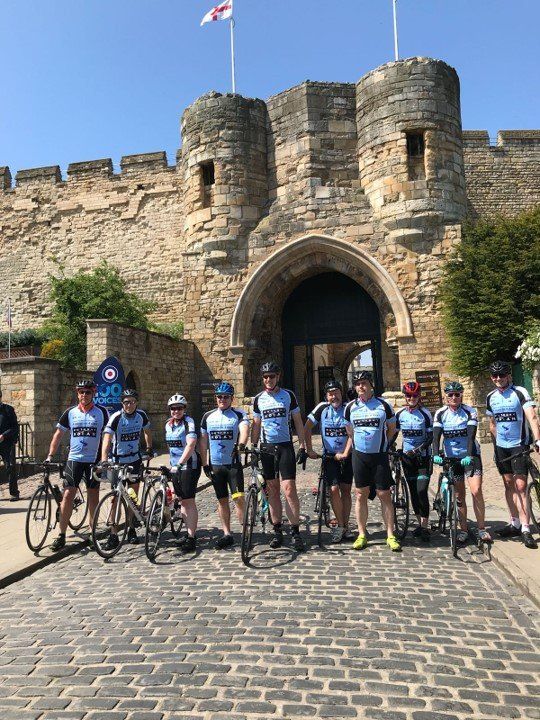 Ten people and bikes outside Lincoln Castle