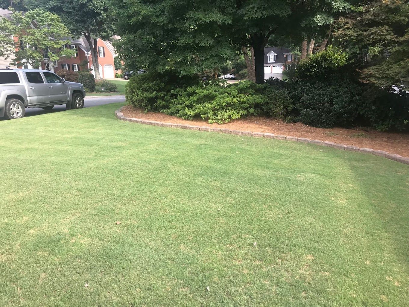 A truck is parked in the middle of a lush green lawn.