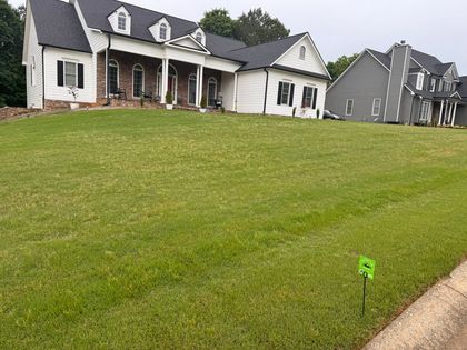 A large house with a lush green lawn in front of it.