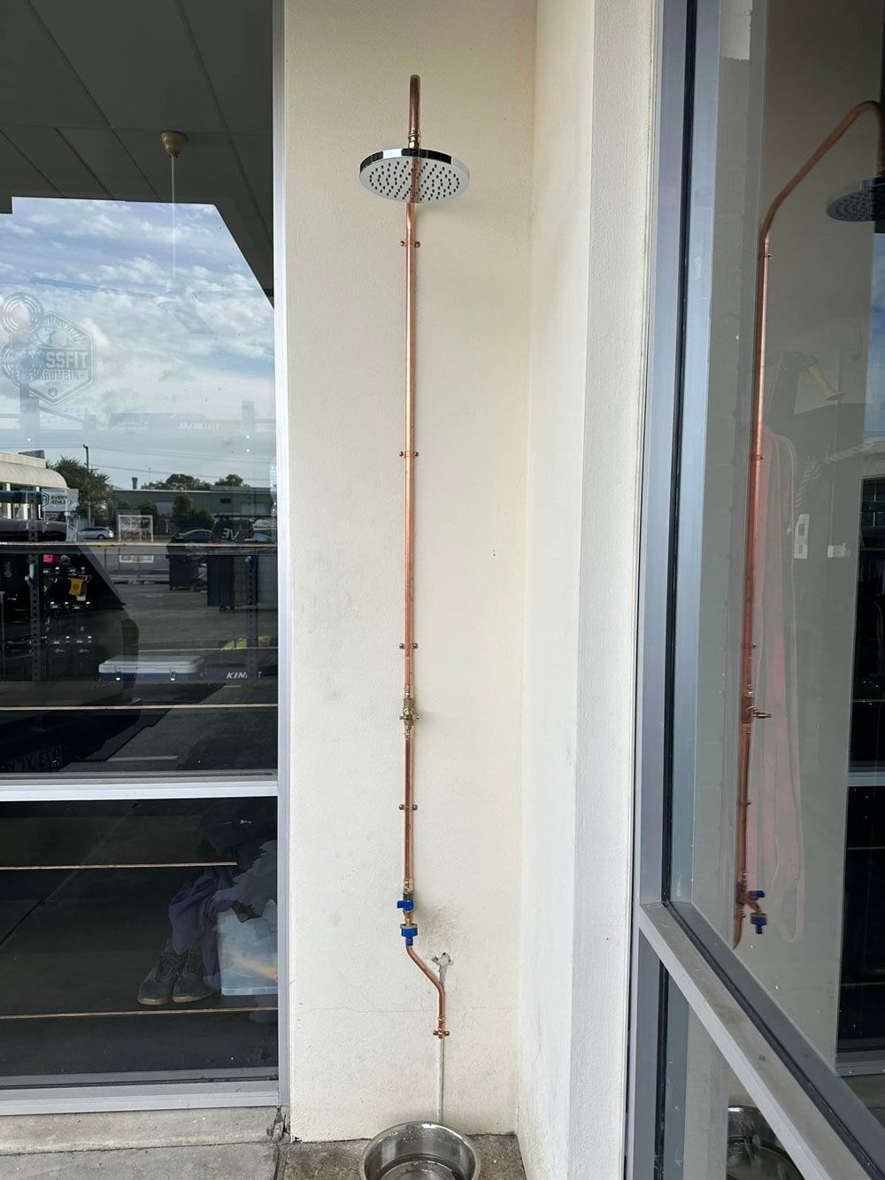 A Copper Pipe Is Attached To A Wall Next To A Window — NSL Plumbing and Gas in Coolangatta, NSW