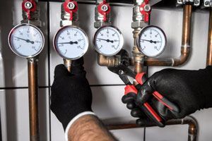 A Plumber Is Fixing A Pressure Gauge On A Pipe — NSL Plumbing and Gas in Banora Point, NSW