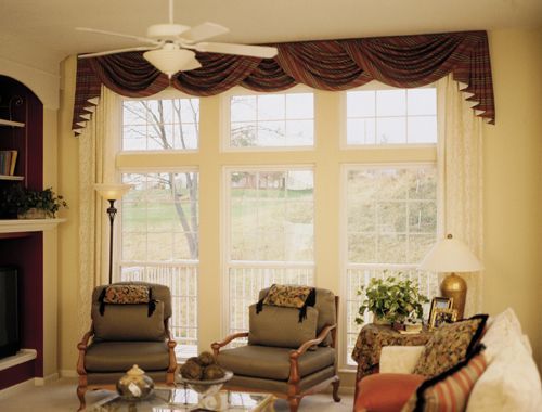 A living room with a lot of windows and a ceiling fan