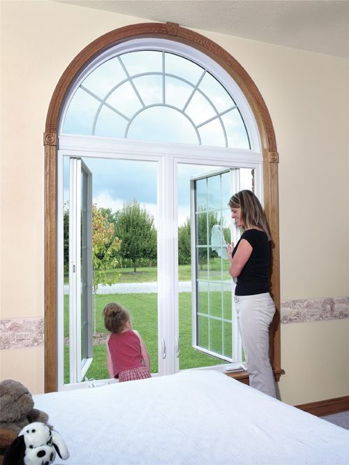 A woman and a child are looking out of an arched window
