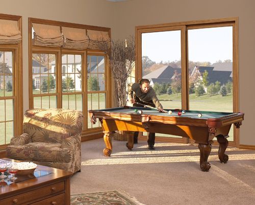 A man is playing pool in a living room