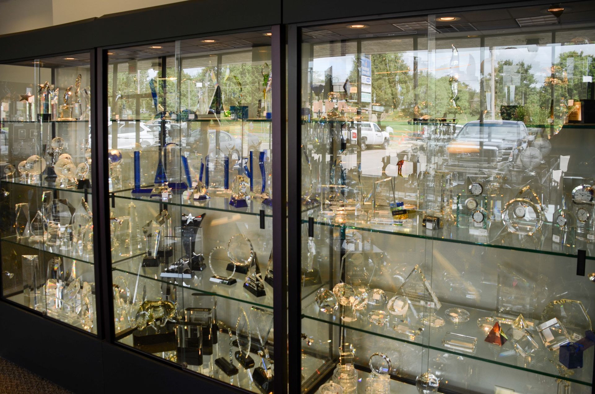 Glass display cabinets filled with assorted glassware and collectibles in a bright room