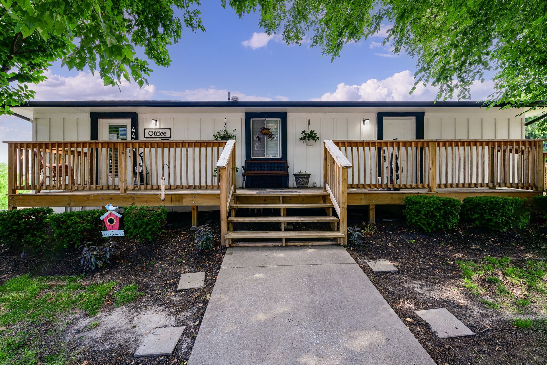 A mobile home with a large deck and stairs