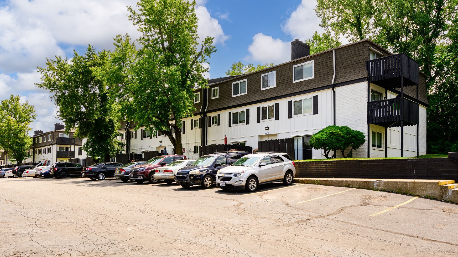 A row of cars are parked in front of a building.