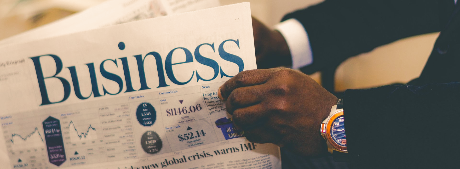 Image of gentleman holding newspaper with the word business in it.