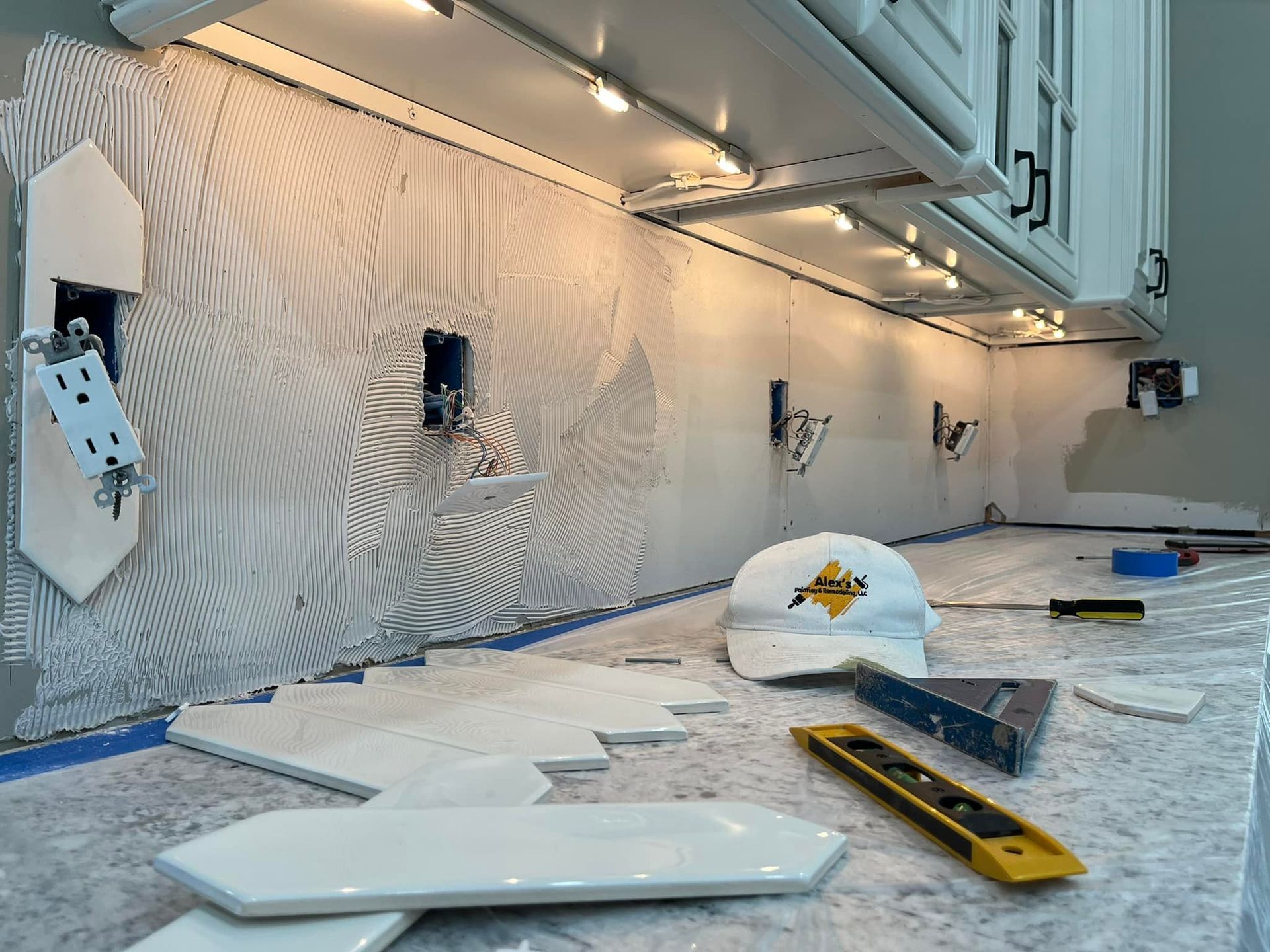A hard hat is laying on the floor in a kitchen.