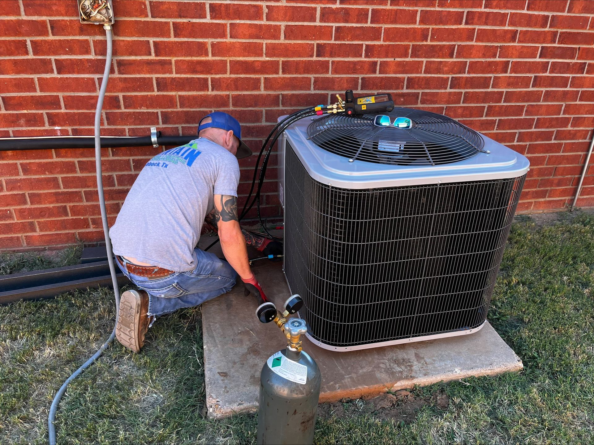 Woman adjusts air conditioner, sitting on sofa with boy and dog. Bright living room.