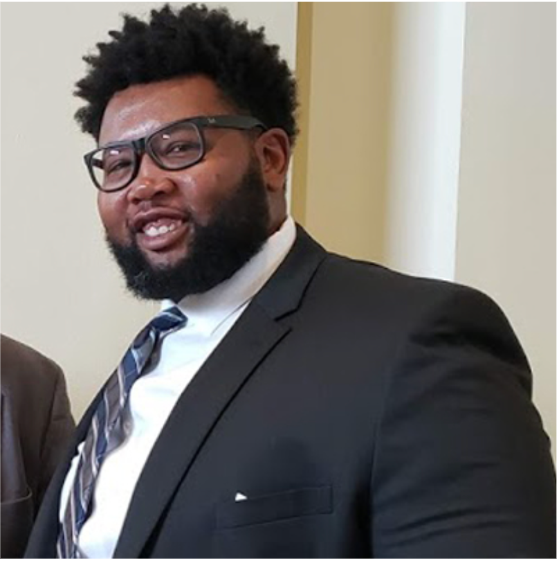 A man in a suit and tie is smiling for the camera