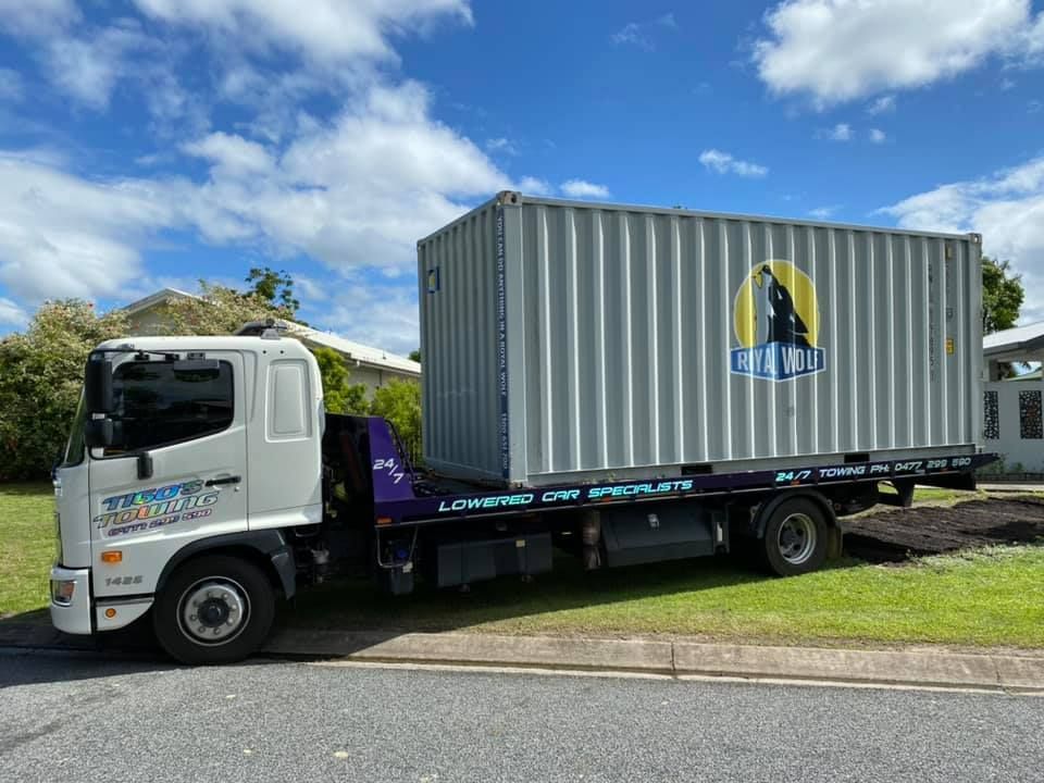 Truck Carrying a Silver Shipping Container on a Sunny Day — Tigo’s Towing In Cairns City, QLD