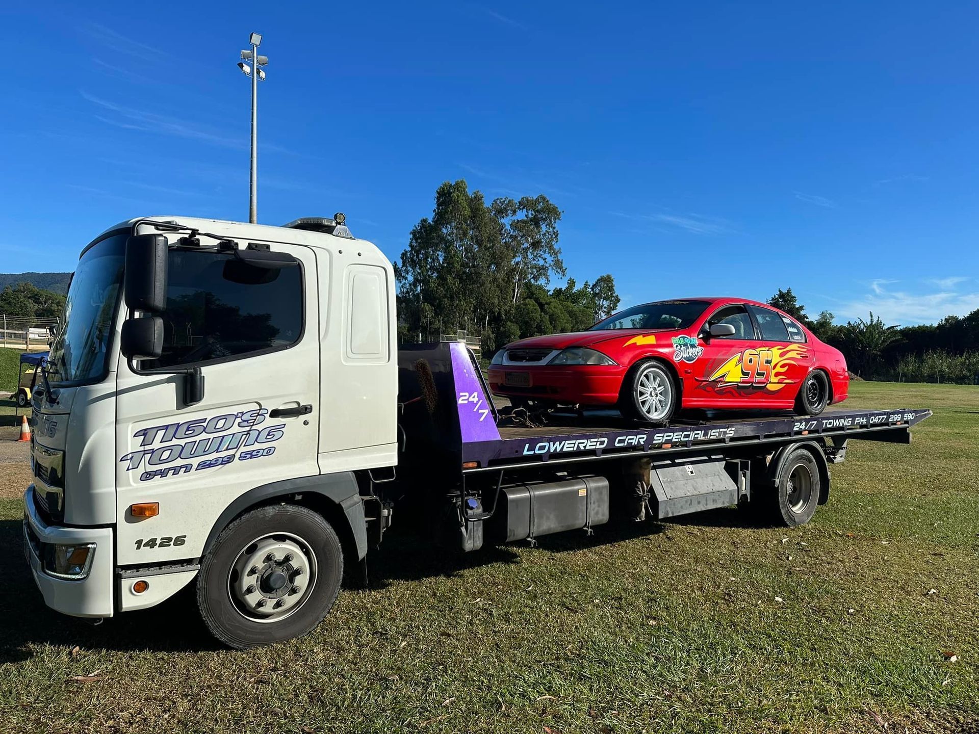 Tow Truck Transporting a Red Car — Tigo’s Towing In Cairns City, QLD