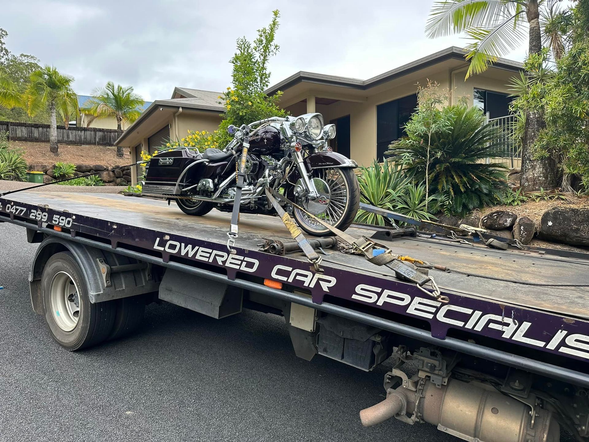 Motorcycle on a Tow Truck, Parked in Front of a House — Tigo’s Towing In Cairns City, QLD