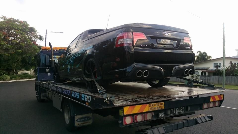 Black Car Loaded Onto a Tow Truck on a Residential Street — Tigo’s Towing In Cairns City, QLD