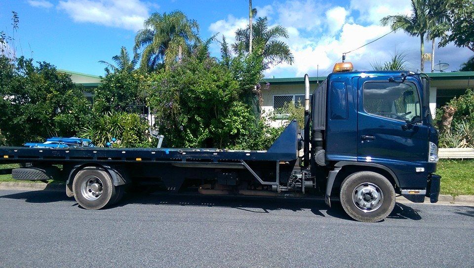 Dark Blue Flatbed Tow Truck Parked on a Paved Road, Daytime — Tigo’s Towing In Cairns City, QLD