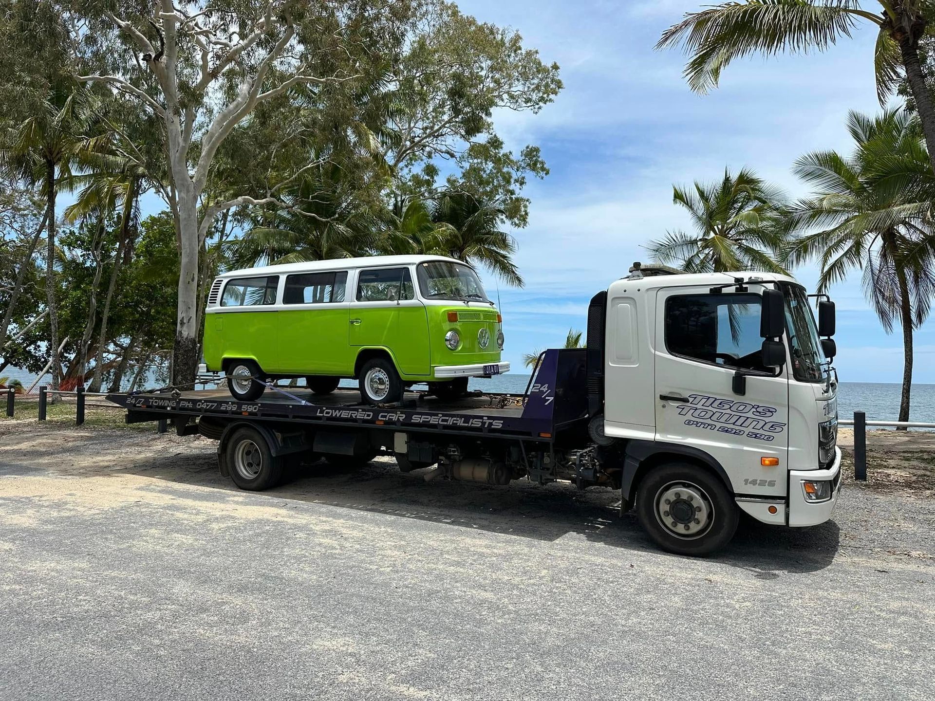 Green and White Volkswagen Bus on a Flatbed Tow Truck by the Beach — Tigo’s Towing In Cairns City, QLD