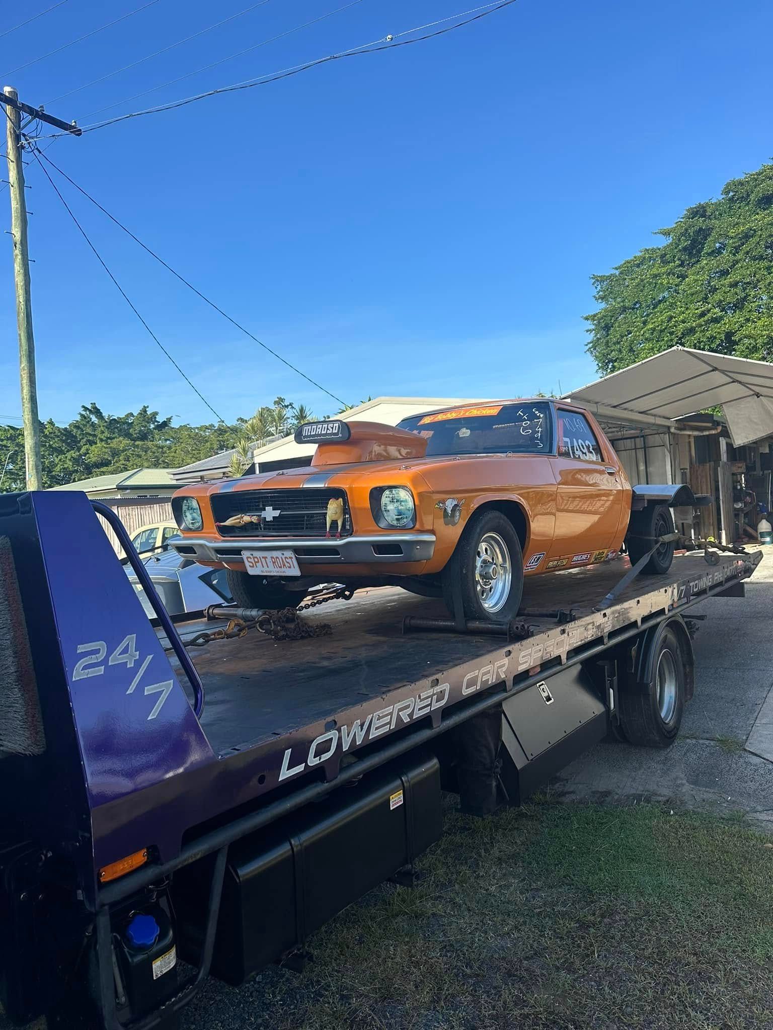 Orange Car on a Tow Truck, Against a Blue Sky — Tigo’s Towing In Cairns City, QLD