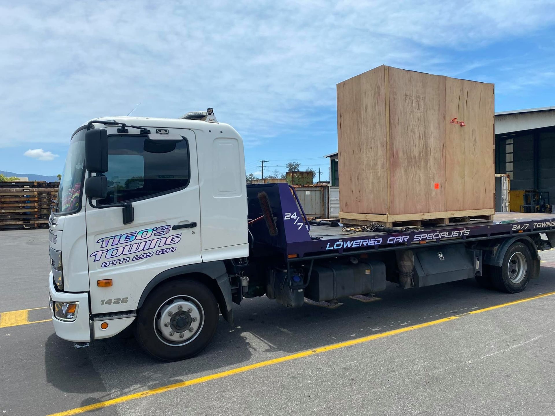 White Flatbed Truck Carrying a Large Wooden Crate on a Pallet — Tigo’s Towing In Cairns City, QLD