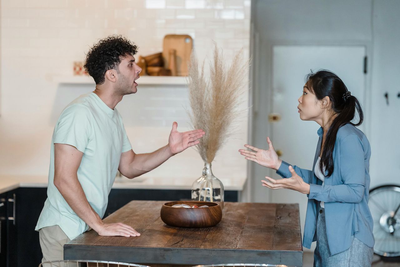 A man and a woman are having an argument in a kitchen.