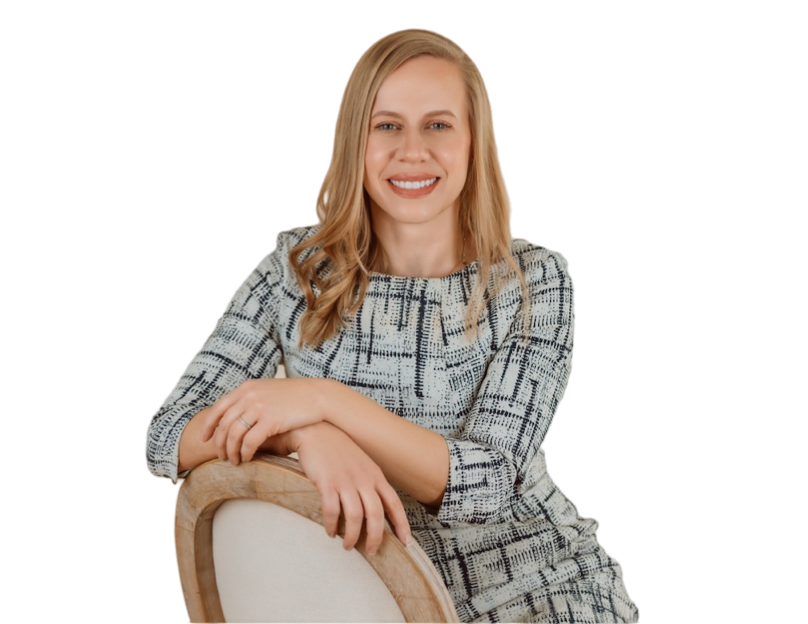 A woman is sitting in a chair with her arm resting on the back of the chair.