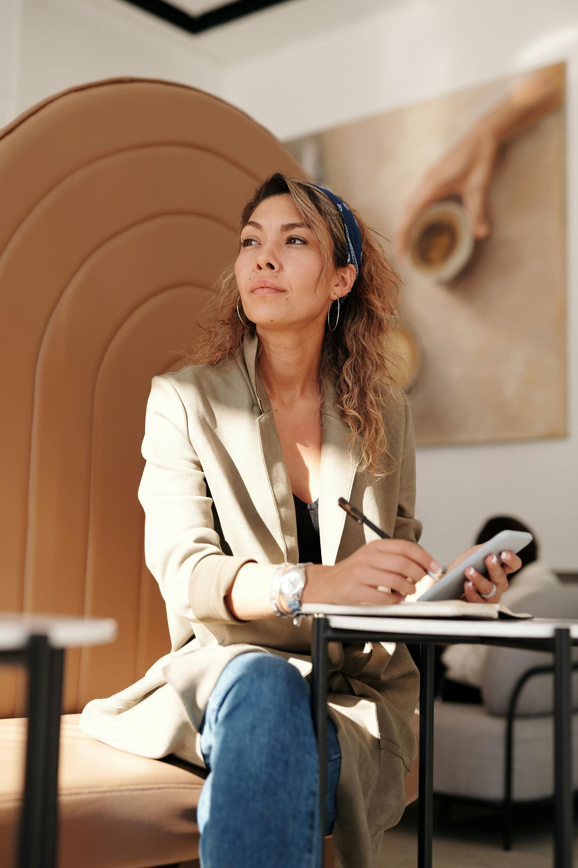 A woman is sitting at a table talking on a cell phone.