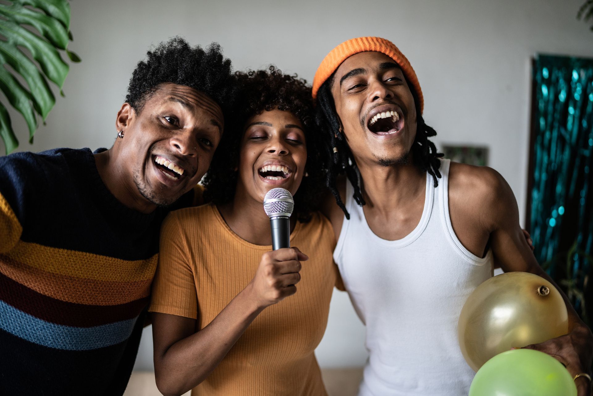 A group of people are singing into a microphone at a party.