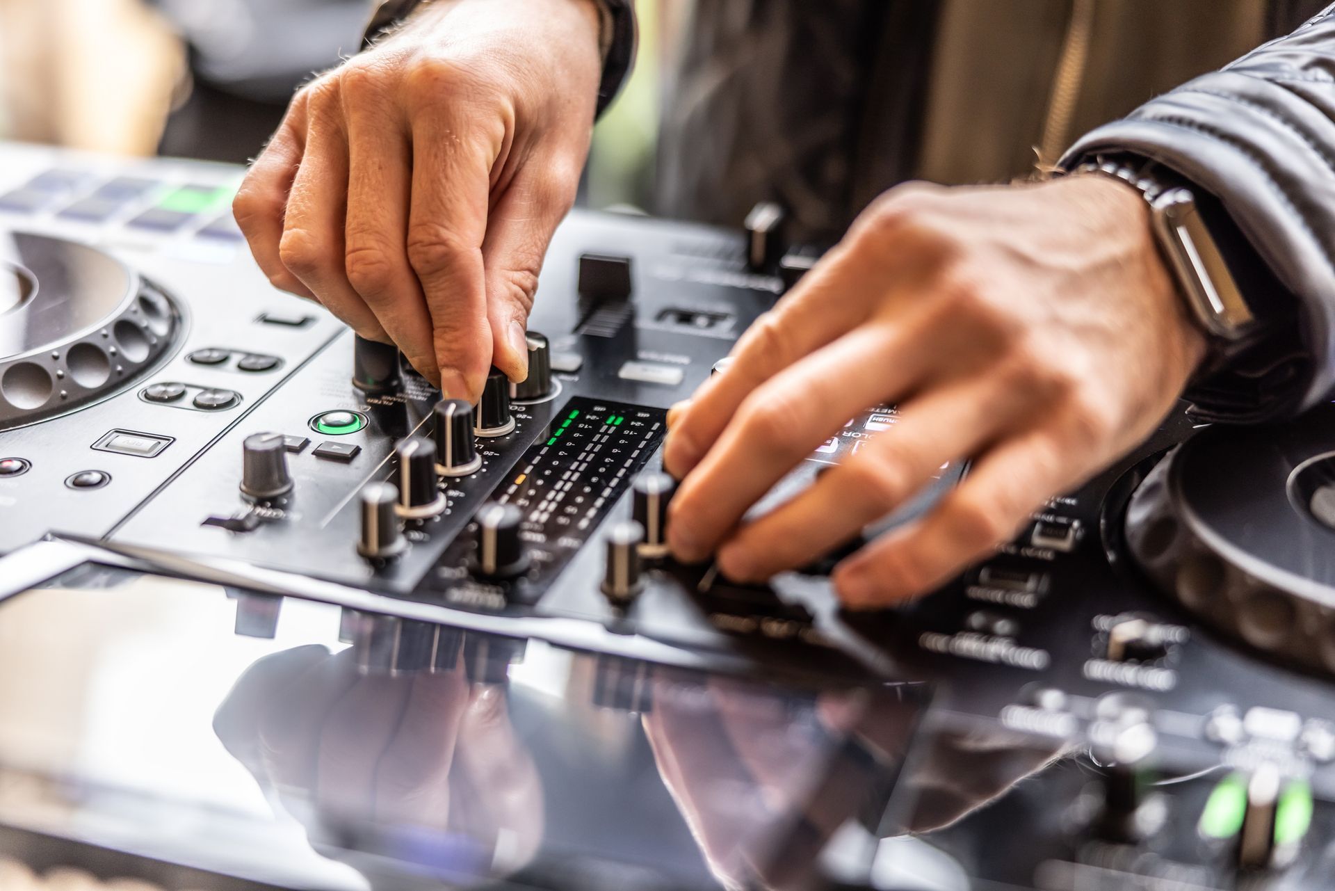 A dj is playing music on a mixer at a party.