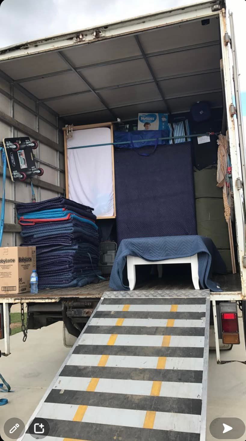 A moving truck interior loaded with furniture and wrapped items, ramp extended. — Gantic Removals Ipswich in Ipswich, QLD
