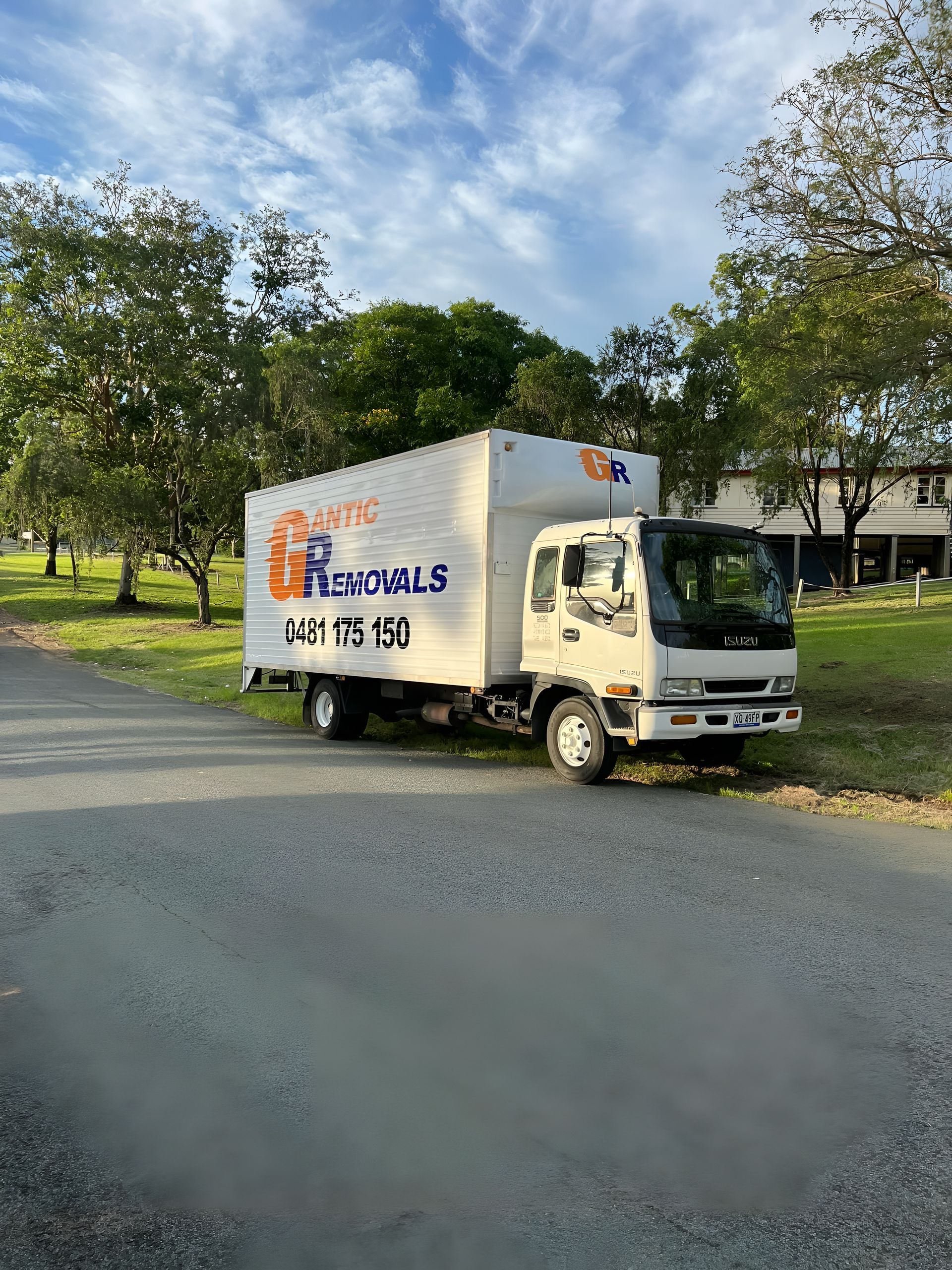 White moving truck parked on a gravel road, with a grassy area and trees in the background. — Gantic Removals Ipswich in Ipswich, QLD