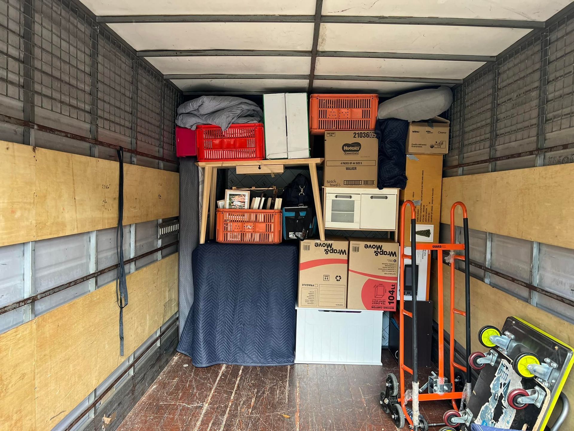 Inside of a moving truck packed with boxes, crates, appliances, and a hand truck. — Gantic Removals Ipswich in Ipswich, QLD