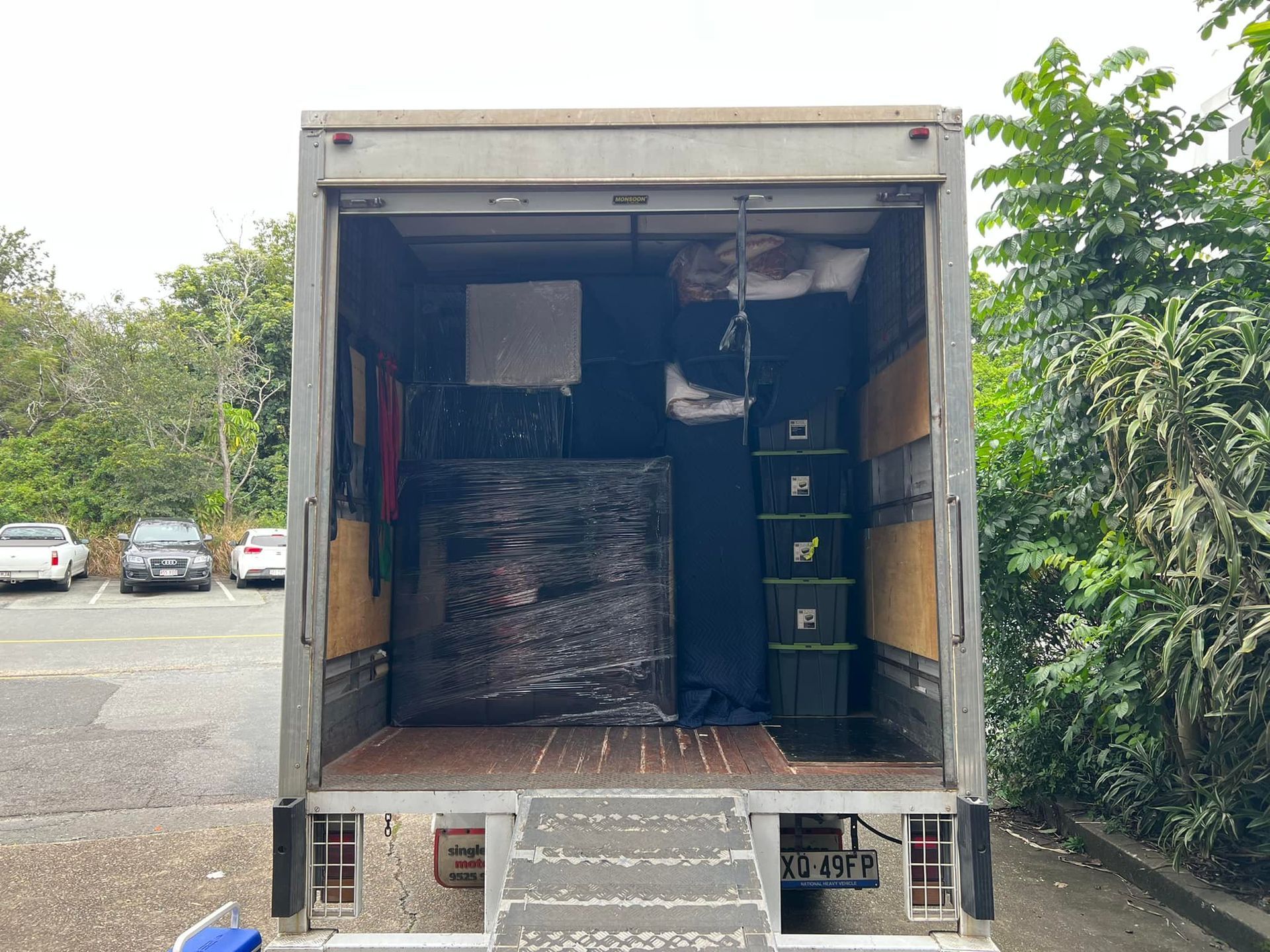 Interior of a moving truck loaded with wrapped furniture and boxes. Tailgate is down, revealing the contents. — Gantic Removals Ipswich in Ipswich, QLD