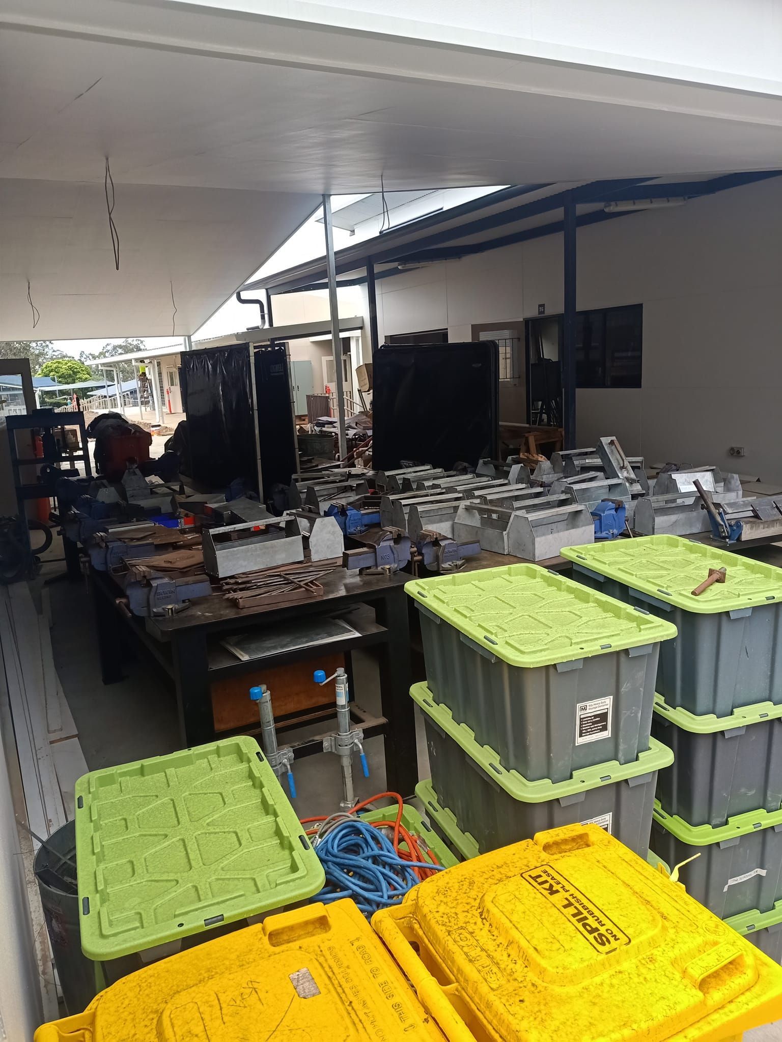 Indoor storage area with piles of electronic equipment, stacked bins, and open doorways. — Gantic Removals Ipswich in Ipswich, QLD