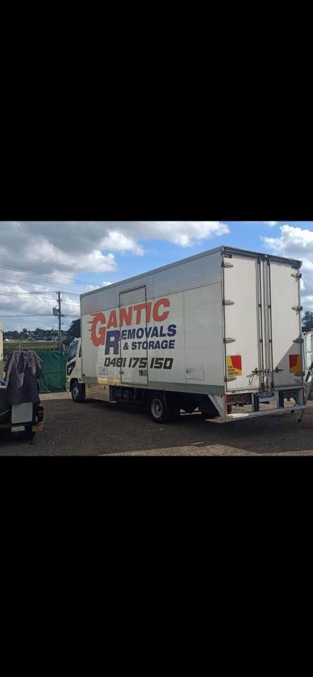 White moving truck parked outside;
