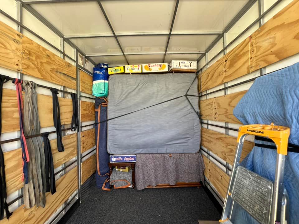 Inside a moving truck, furniture secured with straps. Boxes and a mattress are visible. — Gantic Removals Ipswich in Ipswich, QLD