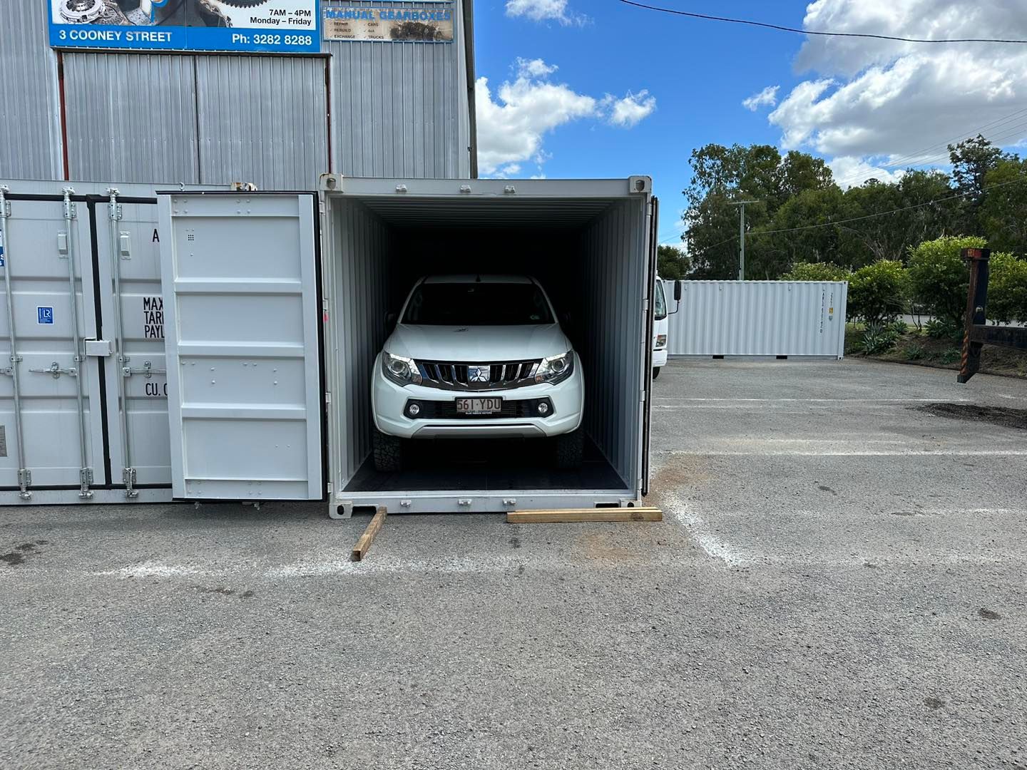 White SUV inside a shipping container, parked on gravel. Another container on the left. — Gantic Removals Ipswich in Ipswich, QLD