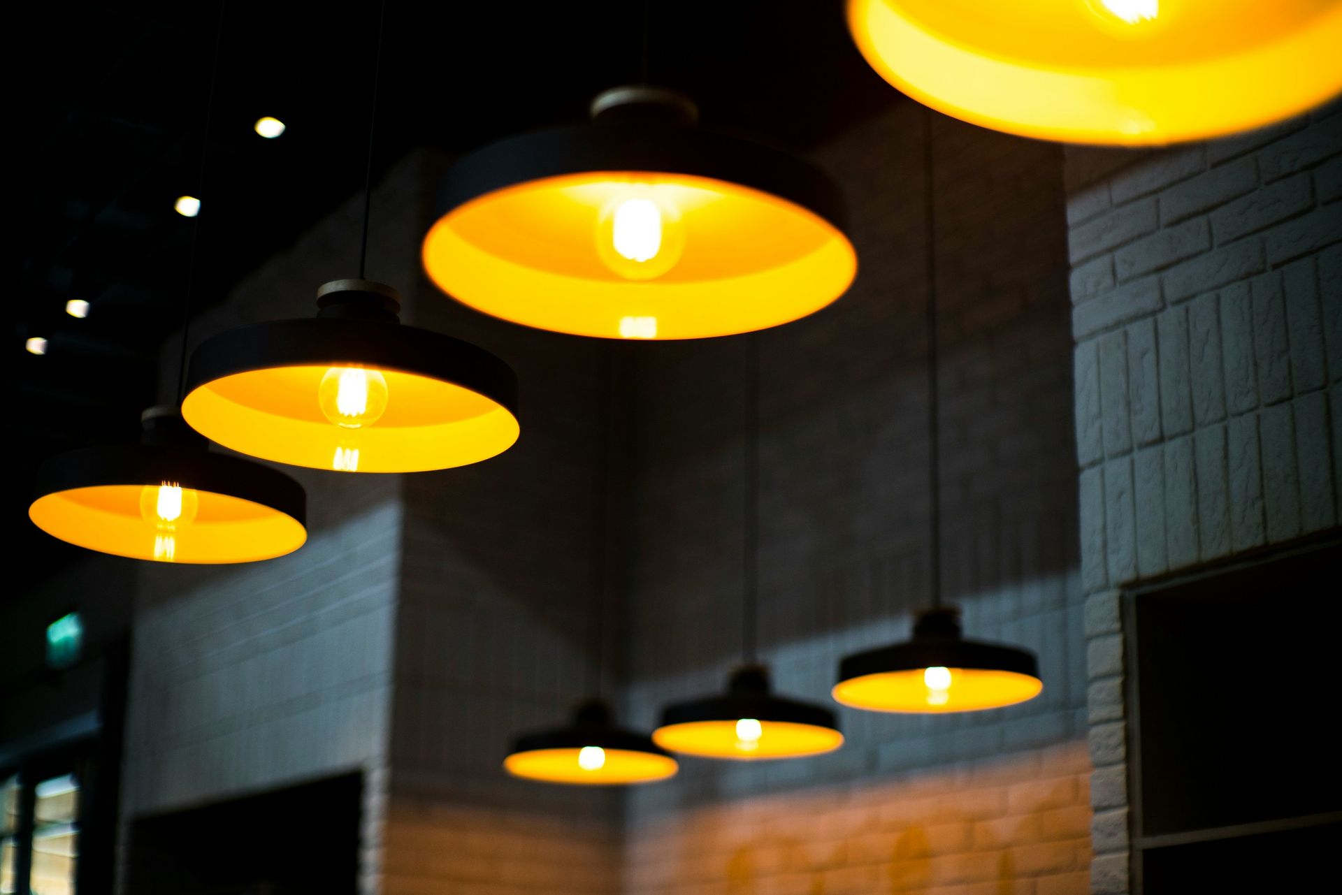 A row of pendant lights hanging from the ceiling in a dark room.