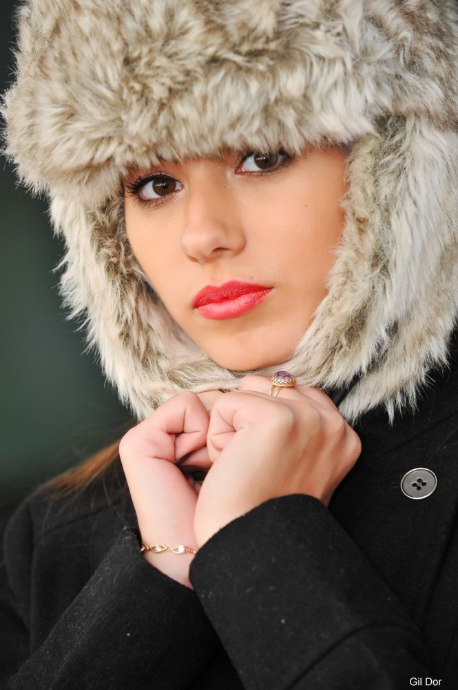 אישה חובשת כובע פרווה ומעיל שחור