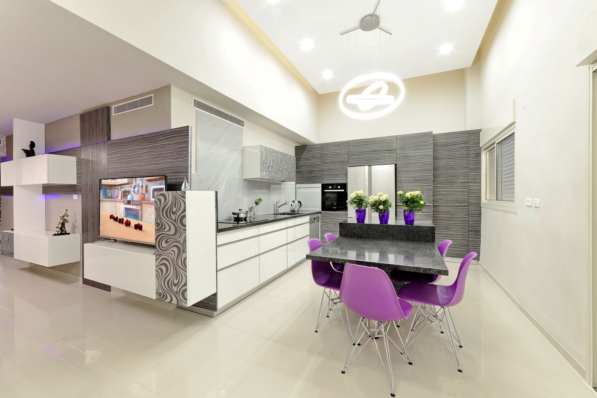 מטבח עם שולחן אוכל וכיסאות וטלוויזיה.