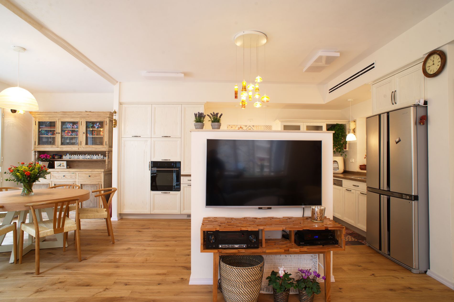 סלון עם טלוויזיה גדולה עם מסך שטוח על מעמד עץ.