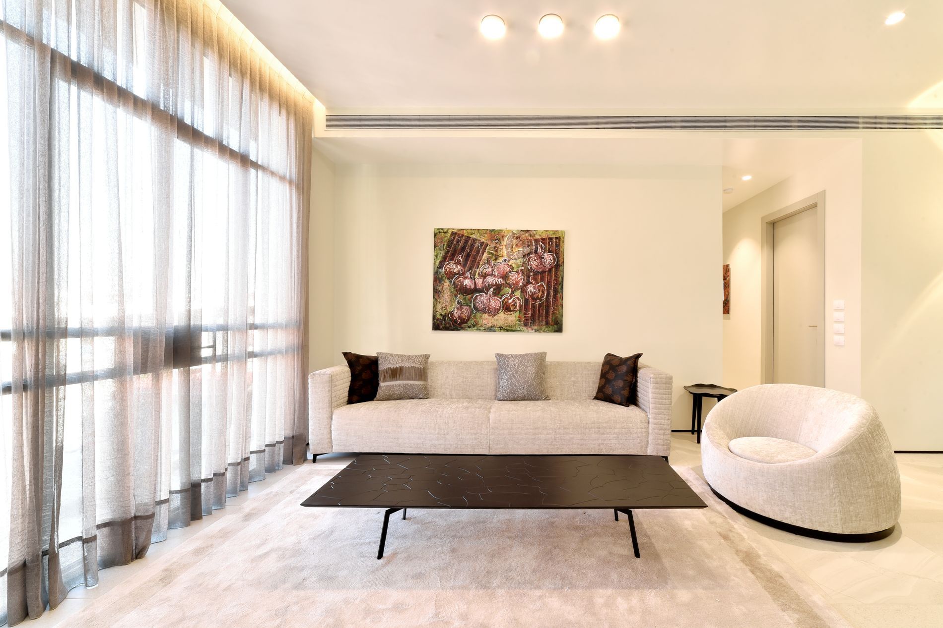 סלון עם ספה, כיסא, שולחן קפה וחלונות גדולים.