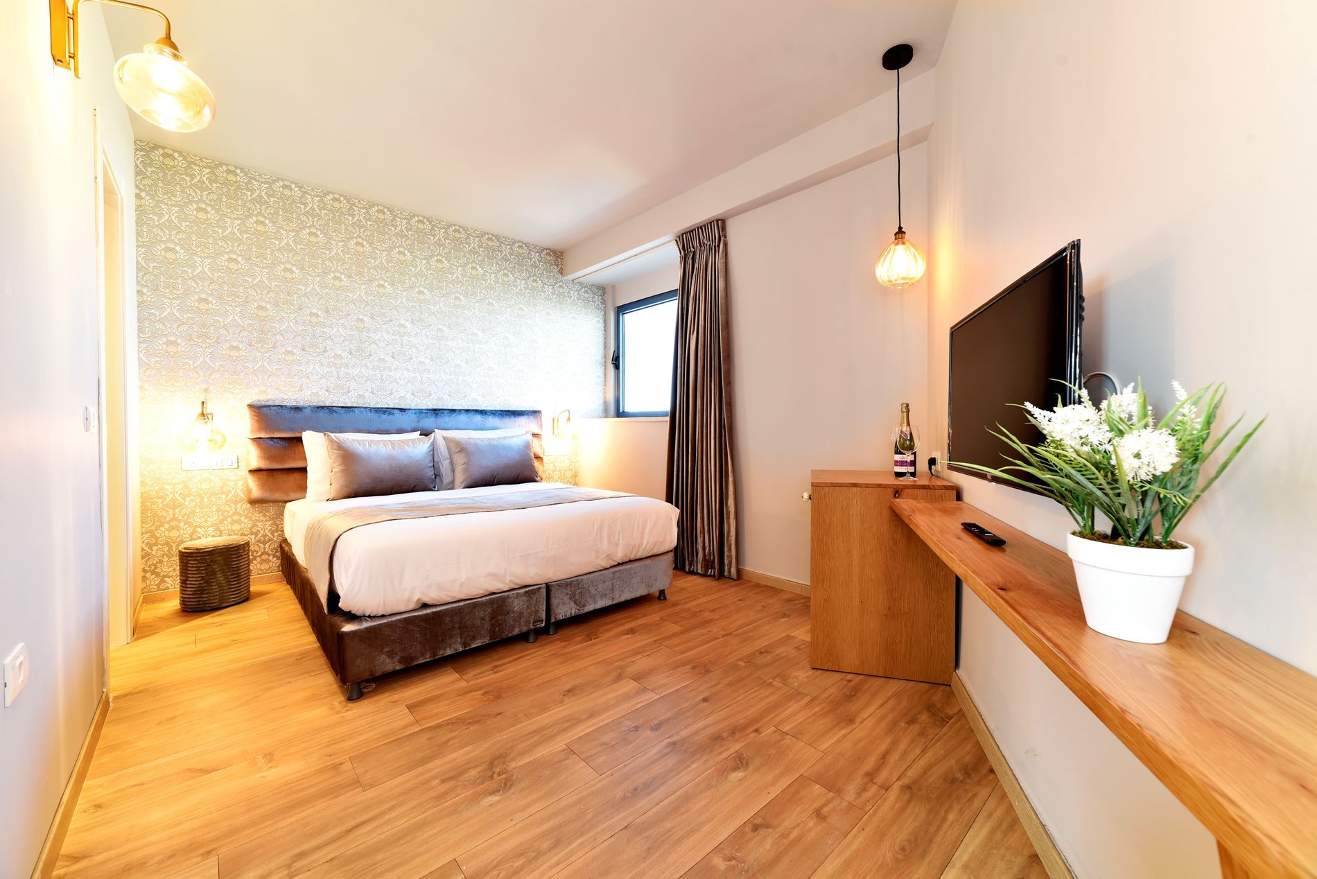 חדר מלון עם מיטה גדולה וטלוויזיה בעלת מסך שטוח.