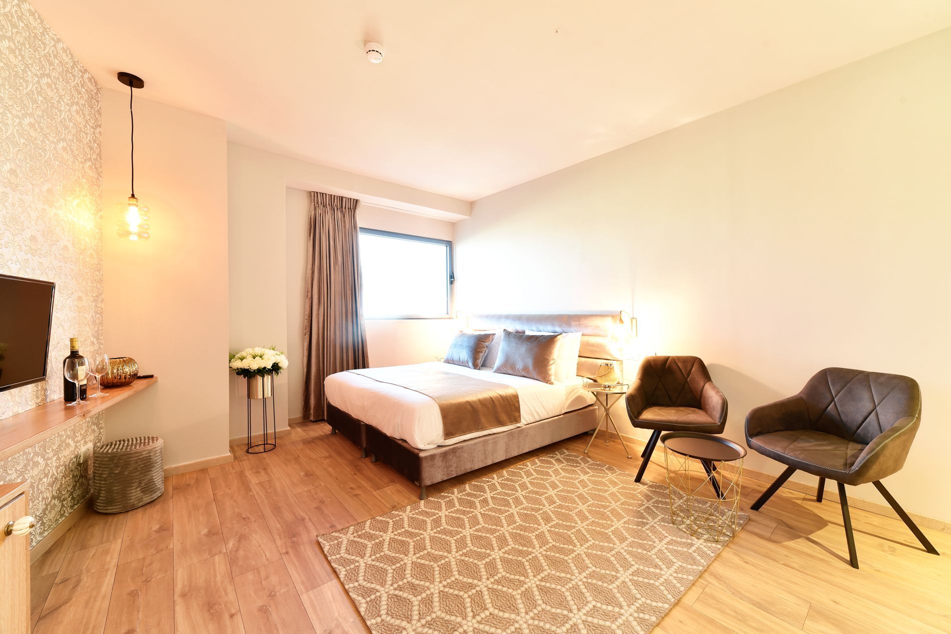 חדר מלון עם מיטה, כיסאות ושטיח.