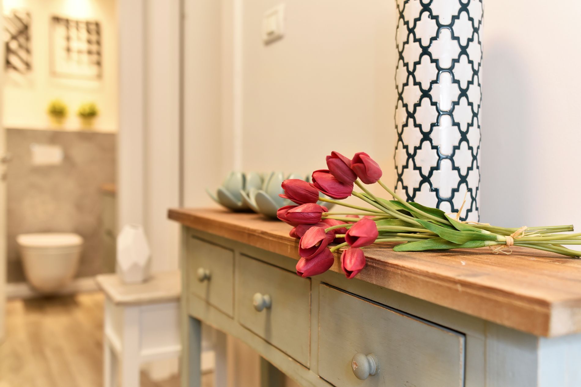 שולחן עם פרחים ואגרטל עליו במסדרון.