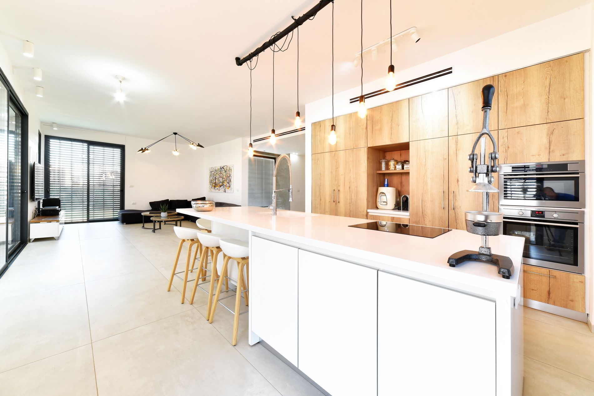 מטבח עם ארונות לבנים וארונות עץ ואי גדול.