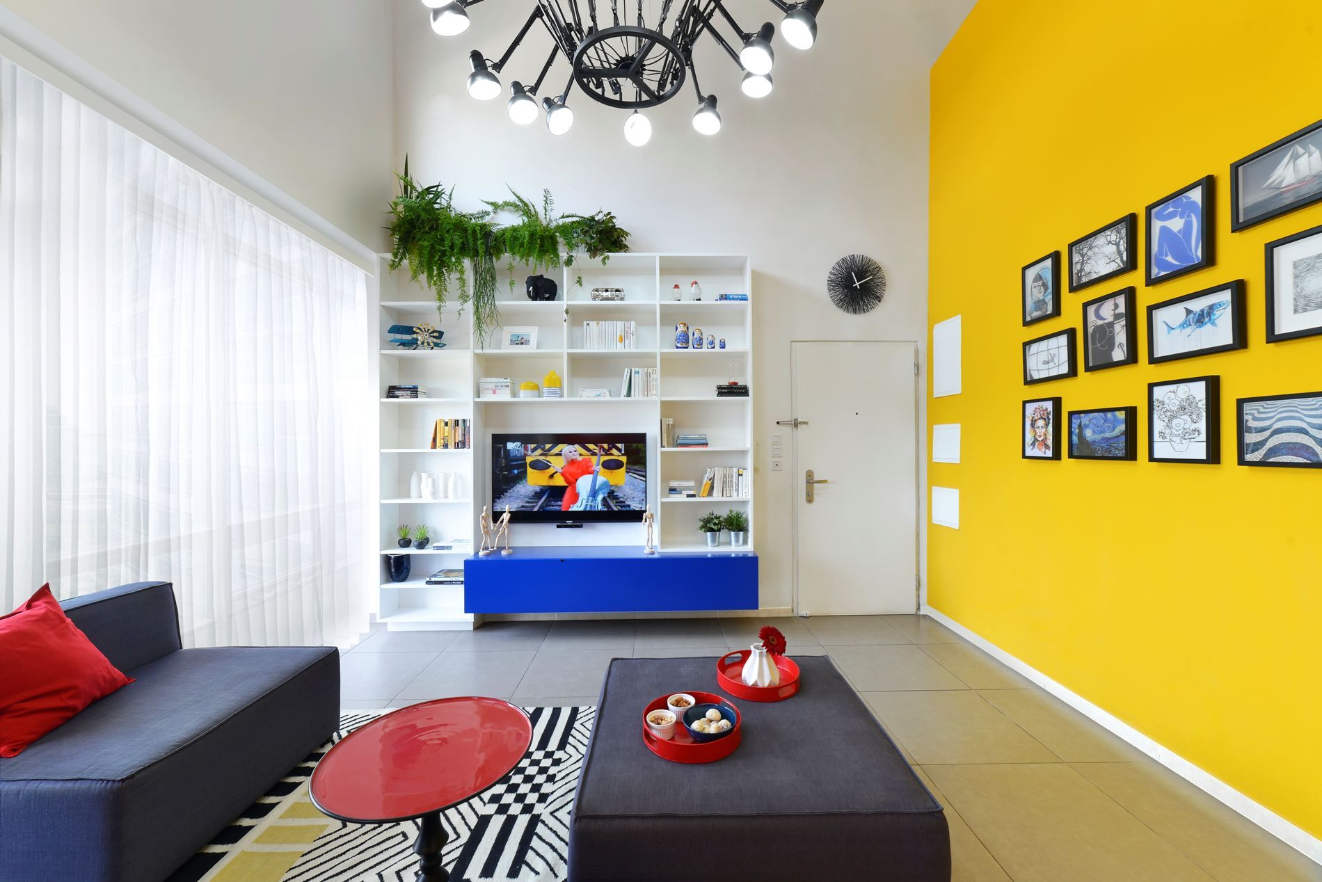 סלון עם קירות צהובים, ספה, שולחן וטלוויזיה.