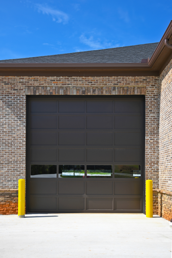 A brick building with a large black garage door